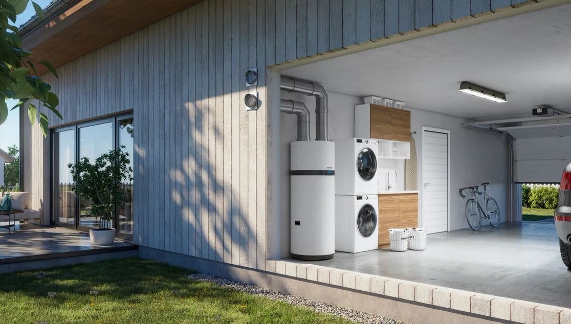 Chauffe-eau thermodynamique installé dans un espace technique attenant à une maison.