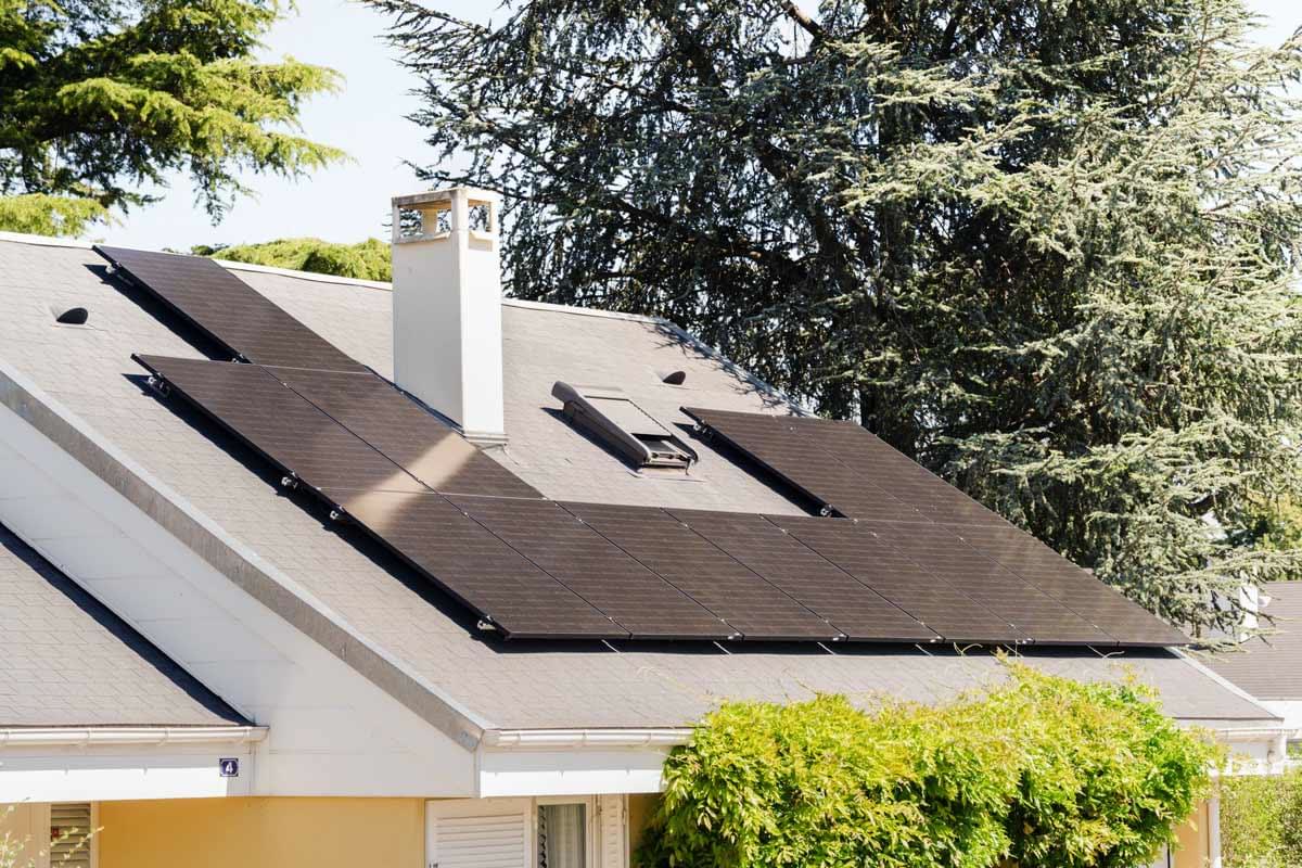 Panneaux photovoltaïques foncés installés sur une toiture en pente.