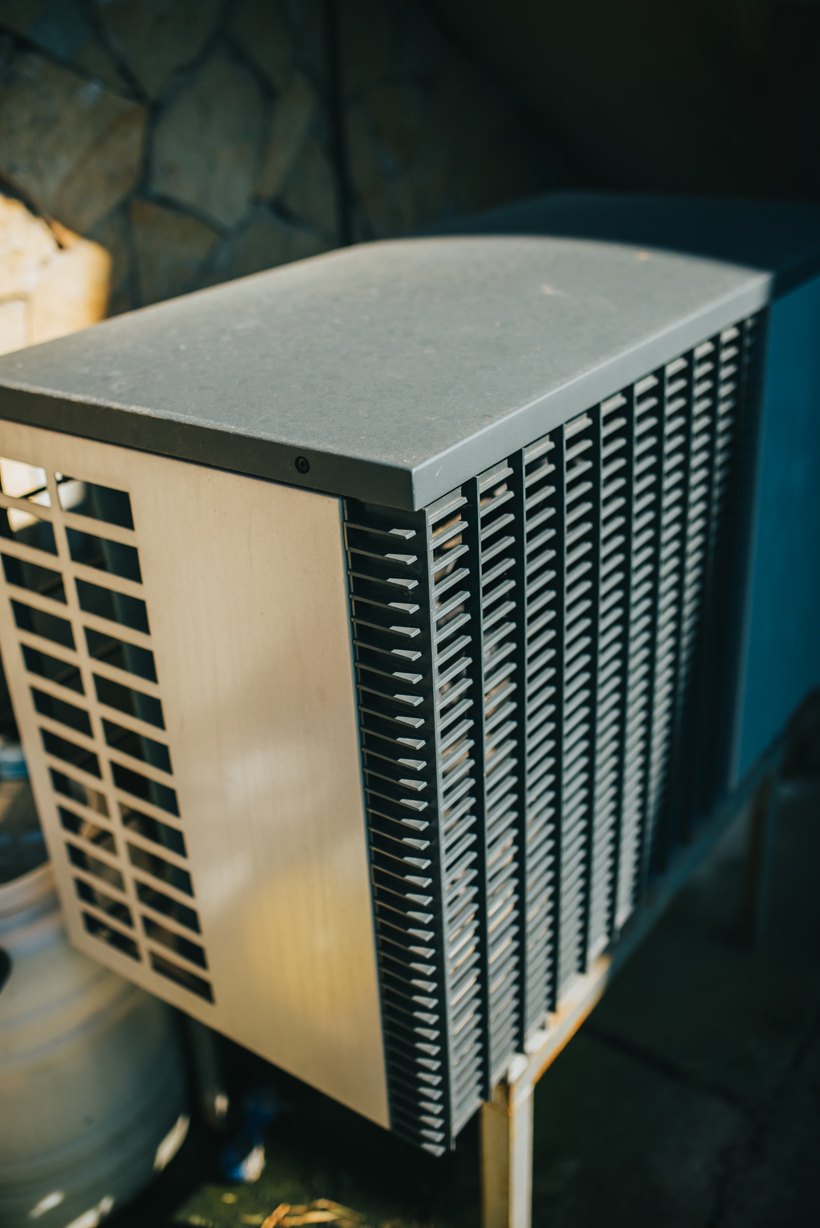 Unité extérieure de climatisation installée dans un jardin résidentiel.